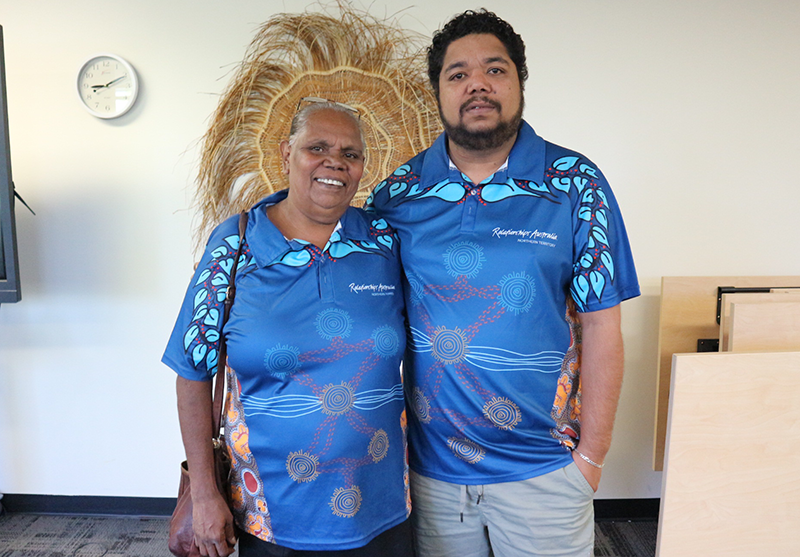 Woman and man smiling wearing Relationships Australia aboriginal uniform