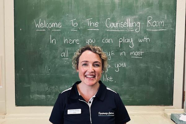 Woman wearing Relationships Australia uniform smiling in classroom