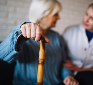 Older woman with walking sticks talking to support worker